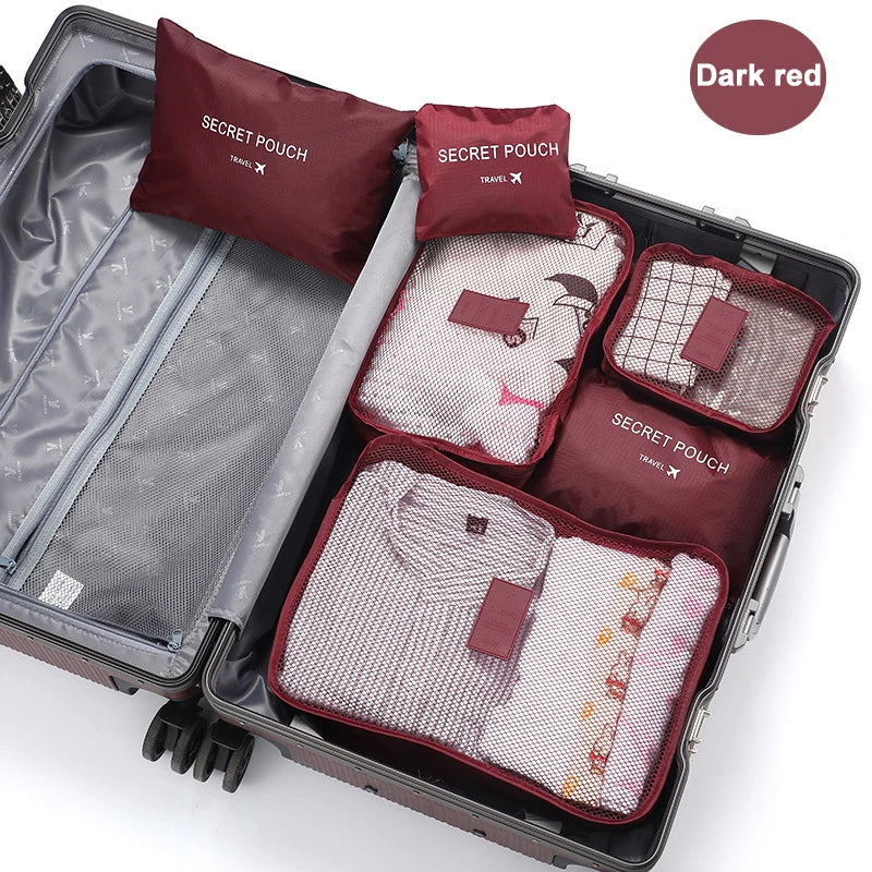 Set of dark red packing cubes labeled 'Secret Pouch' inside an open suitcase.