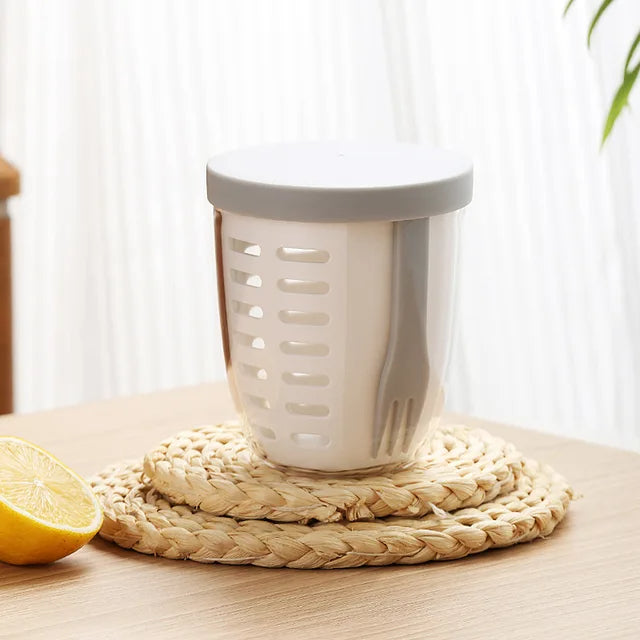 White kitchen tool with a gray top on a woven mat next to a lemon