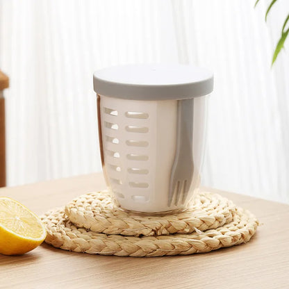 White kitchen tool with a gray top on a woven mat next to a lemon