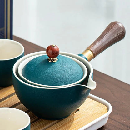 Teal ceramic pot with wooden handle and lid knob on a wooden surface