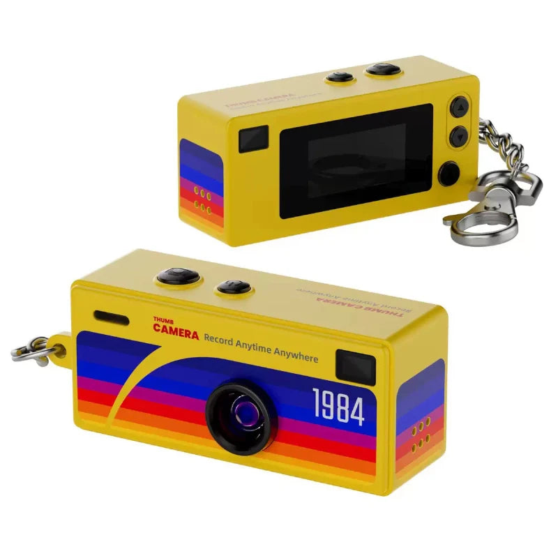 Yellow camera-shaped keychain with colorful design and '1984' text on a white background