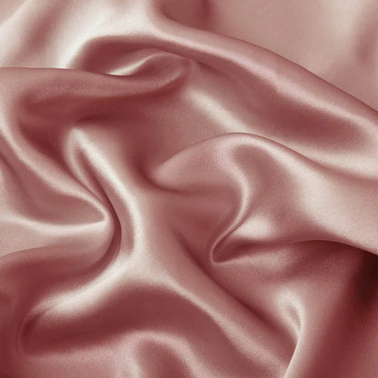 Close-up of pink satin fabric with soft folds
