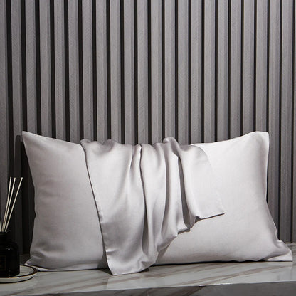 Light Gray pillow on a marble surface with a striped wall in the background