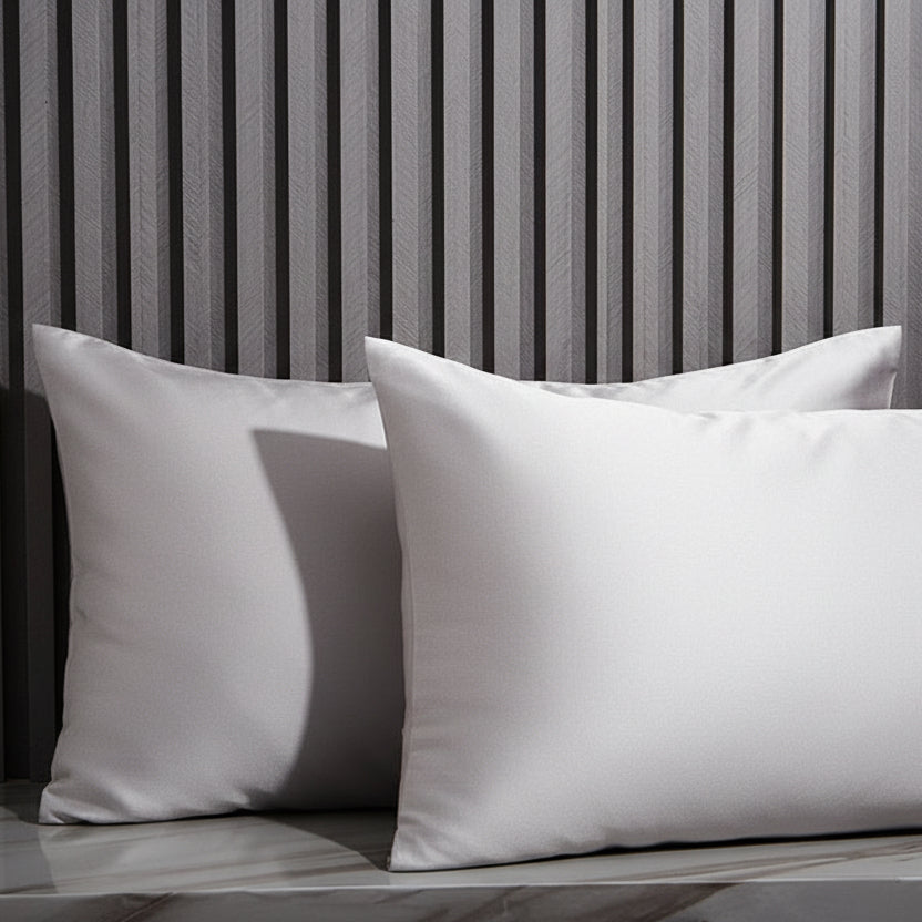 Silver Gray pillows on a marble surface with a striped wall in the background