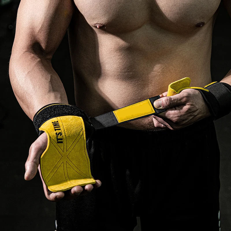 Person wearing yellow wrist wraps with black straps on a dark background
