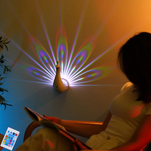 Person sitting in a chair with a colorful peacock light projector on a wall