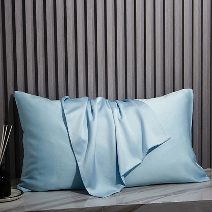Light blue pillows on a surface with a striped wall in the background