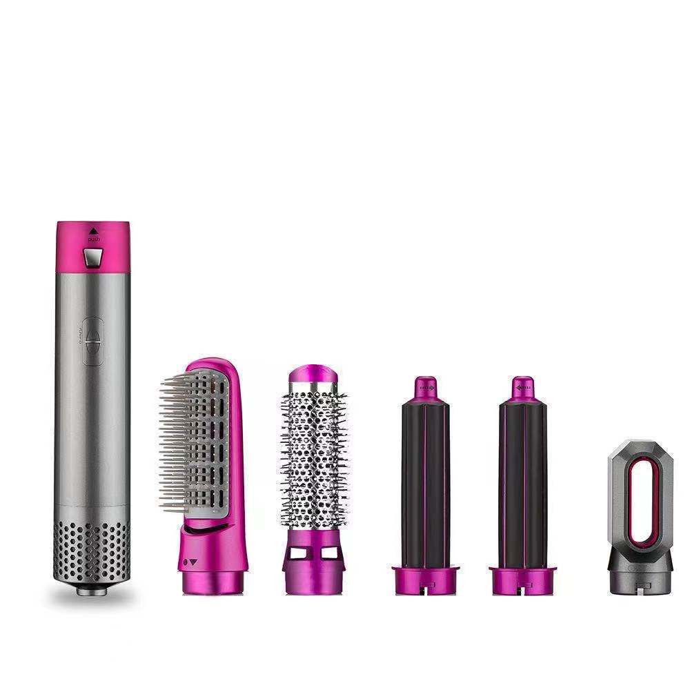Set of hair styling tools with pink and silver accents on a white background