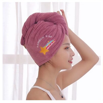 Woman wearing a pink towel with 'Rainbow Star' branding on her head against a white background