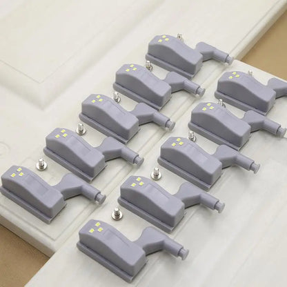 Multiple gray door stoppers arranged on a white surface.