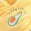 Person wearing a yellow hair towel with avocado design against a neutral background