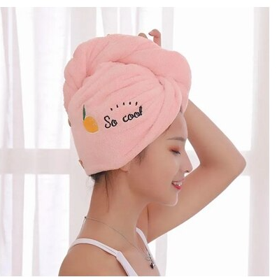 Soft Pink towel turban being worn by a person, with various designs on each.