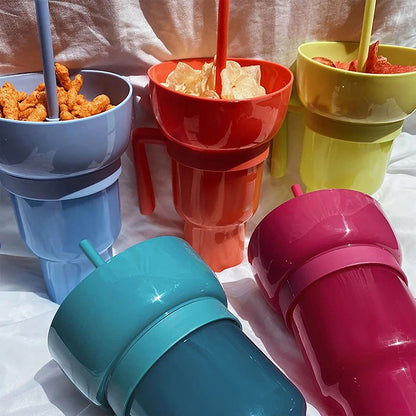 Colorful sippy cups with straws filled with snacks on a white surface.