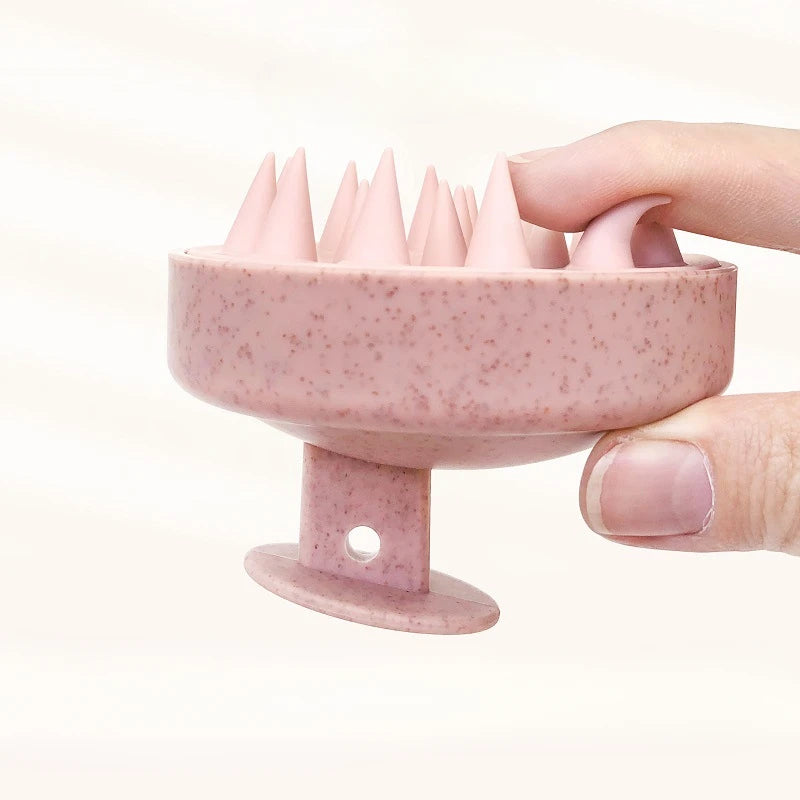 Pink silicone ring with textured design held by a hand on a light beige background