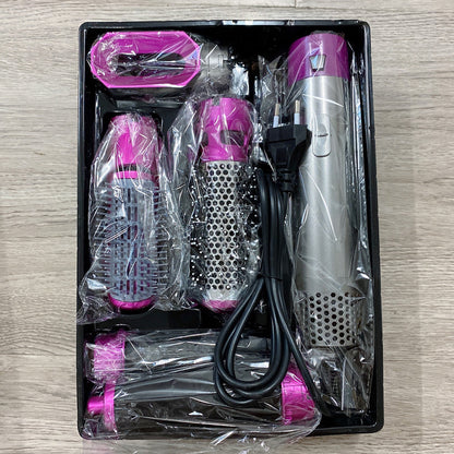 Hair styling tool set with attachments in a black tray on a wooden surface