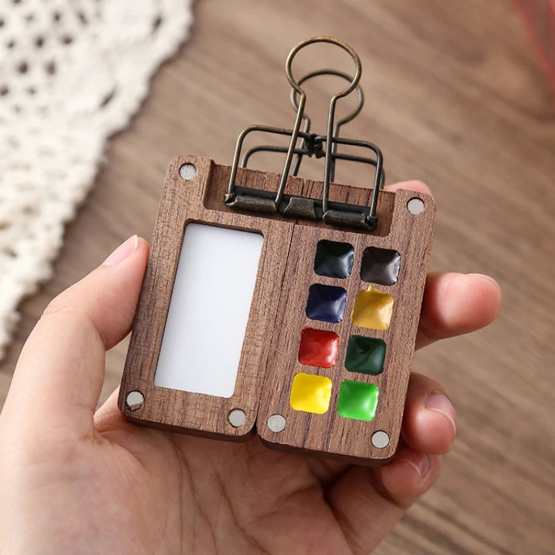 Wooden keychain with colorful square buttons held in a hand against a wooden background