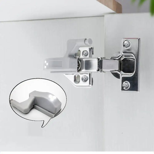 Metallic cabinet hinge on a white surface with an inset showing a close-up of the hinge.