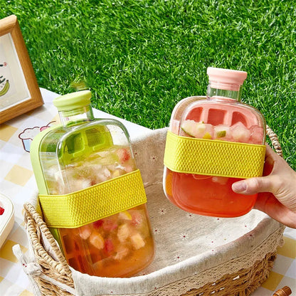 Two colorful water bottles with yellow straps on a grassy outdoor setting.