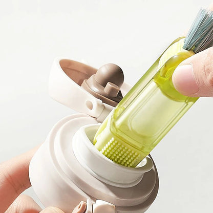 Bottle brush cleaning tool with a green brush head held by a hand on a white background