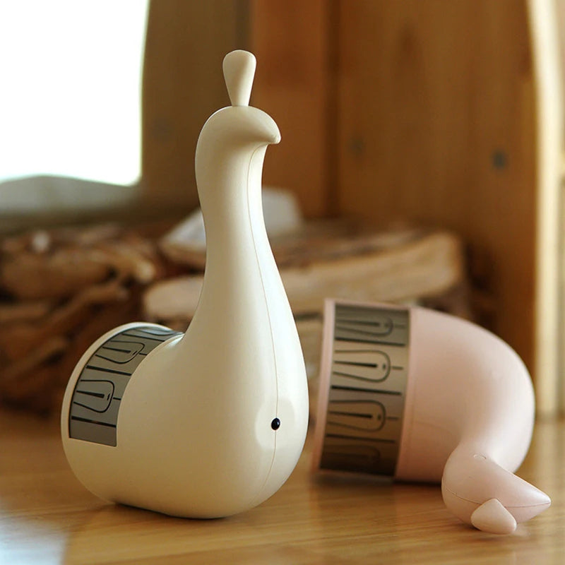 White ceramic peacock lamp on a wooden side table