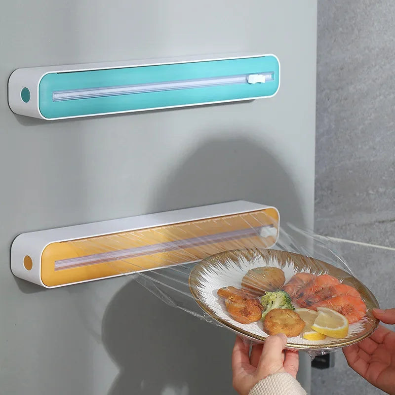 Two food dehydrators on a gray wall with a plate of food held by a person.