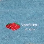 Woman holding colorful towels with a pink towel on her head indoors.