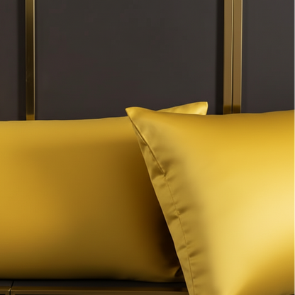 Gold satin pillowcases on a dark background