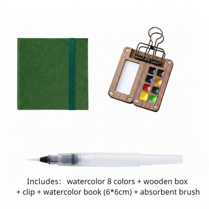 Schmincke watercolor set with wooden box, clip, watercolor book, and absorbent brush on a white background.