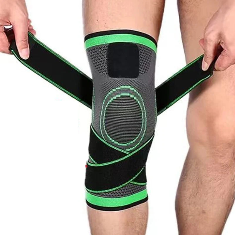 Knee brace with green accents being worn on a person's leg against a white background