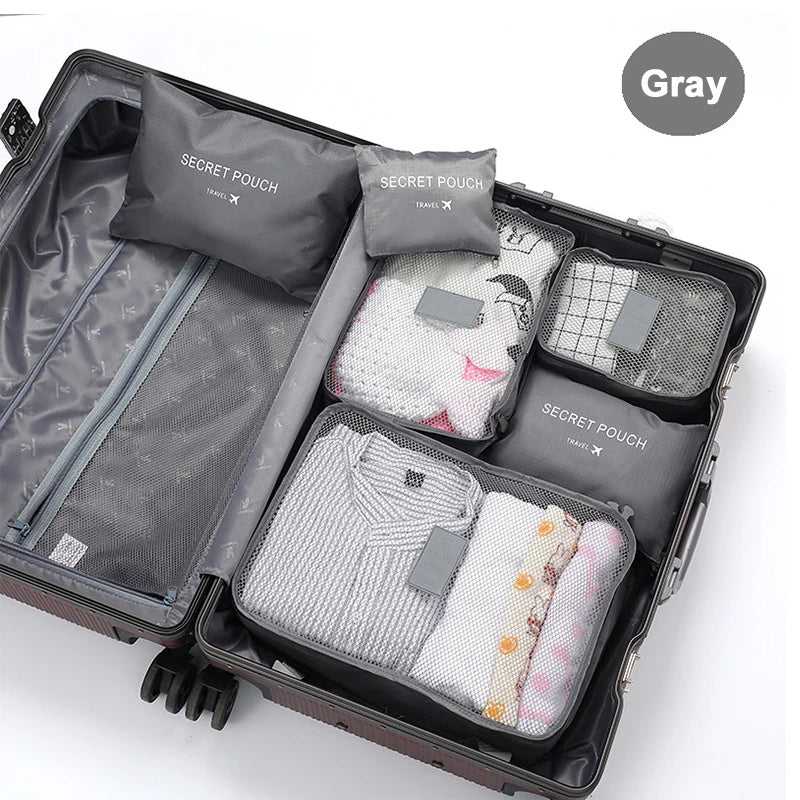 Open suitcase with gray packing cubes labeled 'Secret Pouch' on a white background