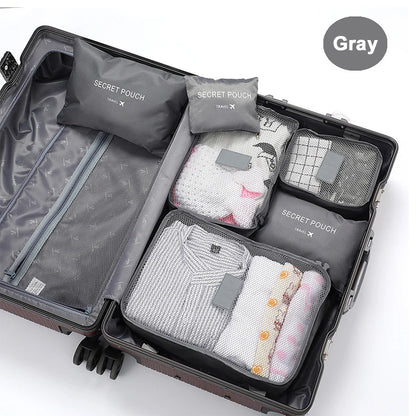 Open suitcase with gray packing cubes labeled 'Secret Pouch' on a white background