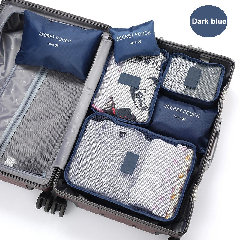 Open suitcase with travel packing cubes labeled 'Secret Pouch' on a white background.