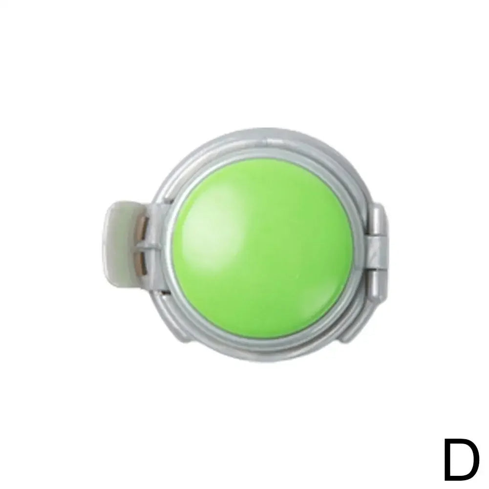 Round green object with a metallic rim on a white background