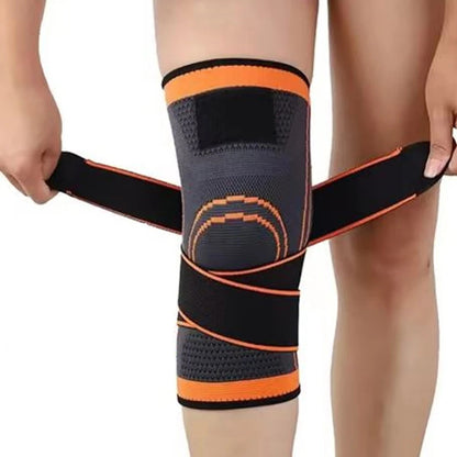 Black and orange knee brace being worn on a person's leg against a white background
